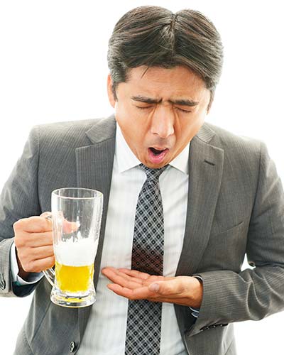 мужчина в костюме со стаканом пива в руке